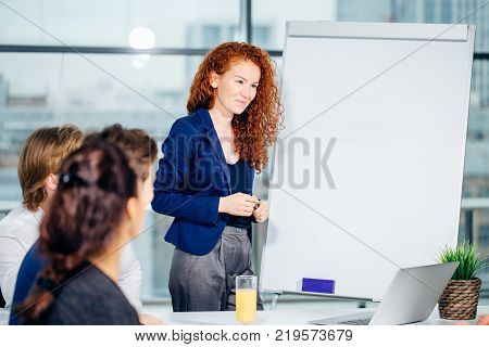 Presentation in business seminar analysing flipchart. woman showing her project on magnetic board
