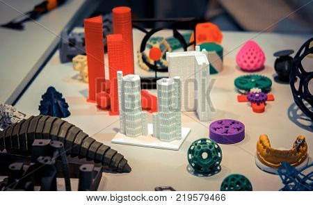 Many abstract models bright colorful objects printed on a 3d printer on a white table. Fused deposition modeling, FDM. Progressive modern additive technology. Concept of 4.0 industrial revolution