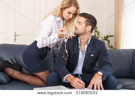 Sexy blonde secretary offering handcuffs for rich young boss in office bdsm toy