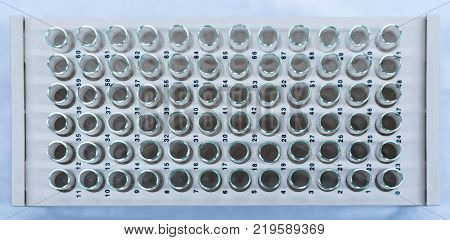 Chromatography fraction collection tubes on a rack in a lab as viewed from the top