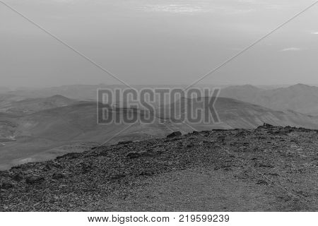 White and black mystic blue morning landscape view on negev judean desert in Israel. History location object in antient place. Rocks sand mountains and sunrise
