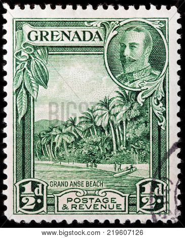 LUGA RUSSIA - OCTOBER 7 2017: A stamp printed by GRENADA shows image portrait of King George V against beautiful view of Grand Anse white sand beach circa 1934