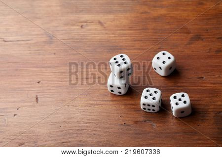 Stack of dice on rustic wooden table. Gambling devices. Game of chance concept. Copy space for text.