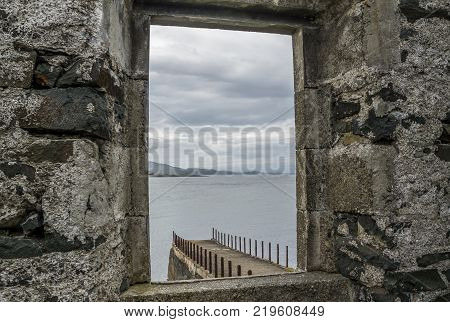 The rotten pier at Craignish point with the Sound of Jura in the background, Scotland