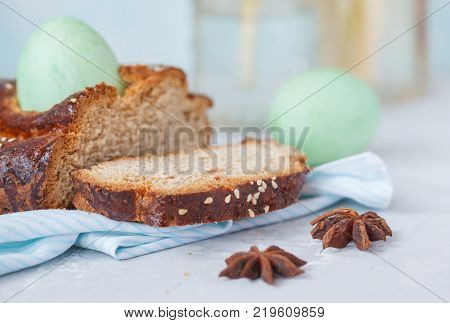 Traditional Greek Easter bread - tsoureki sliced in Easter decoration with painted eggs and flowers. Easter Festival concept.