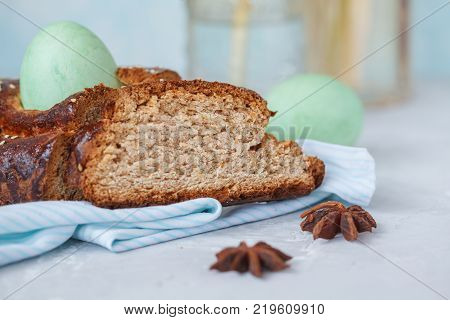 Traditional Greek Easter bread - tsoureki sliced in Easter decoration with painted eggs and flowers. Easter Festival concept.