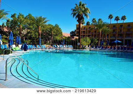December 18, 2017 in Palm Springs, CA:  Large swimming pool within a courtyard taken at the Renaissance Hotel in Palm Springs, CA where guests can sunbathe and go swimming surrounded by beautiful desert gardens
