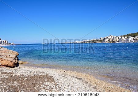 SAN PAWL, MALTA - APRIL 2, 2017 - Rocky beach with views across the bay towards St Pauls Bay, San Pawl, Malta, Europe, April 2, 2017.