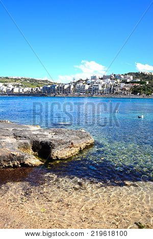 Shoreline with views across the bay towards St Pauls Bay San Pawl Malta Europe.