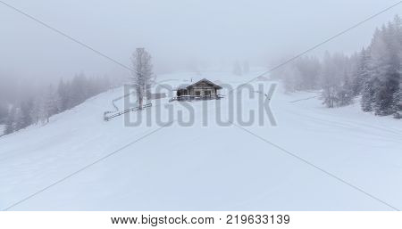 snowy and foggy montain wooden cabin landscape