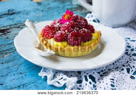 Tartlet With Fresh Raspberries And Spoon On Blue.tartlet With Fresh Raspberries And Spoon On Blue.ta
