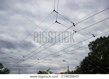 Tram wires (overhead lines railroad trolley line) on the sky background.