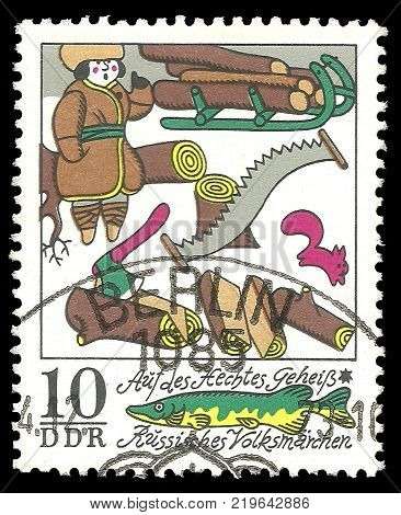 Germany - circa 1973: Stamp printed by GDR Color edition on Russian Winter Fairy Tales shows On the pike behest chopping wood circa 1973