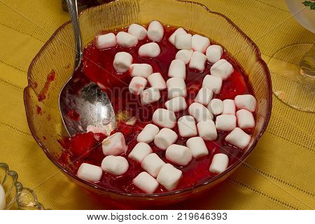 a bowl of strawberry and bananas jello topped with marshmellos
