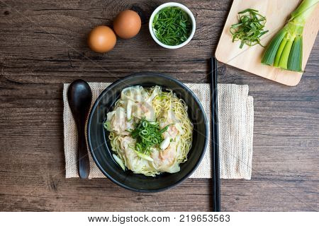 Shrimp wonton with braised pork in soup on wooden table - Asian food style Select focus image