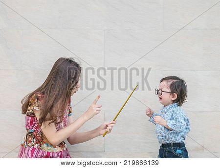 Closeup asian kid was scolded by his mother on blurred marble stone wall textured background with copy space