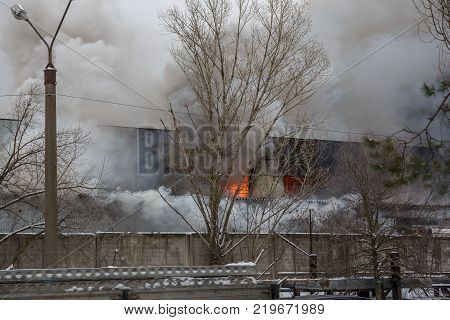 Fire in an industrial warehouse or Factory on Lantenskaya Street in Voronezh, rubber is burning, lots of smoke and flames, firefighters and MES rescue workers are struggling with a fire