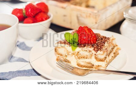 Homemade tiramisu cake decorated with strawberries Italian cuisine,