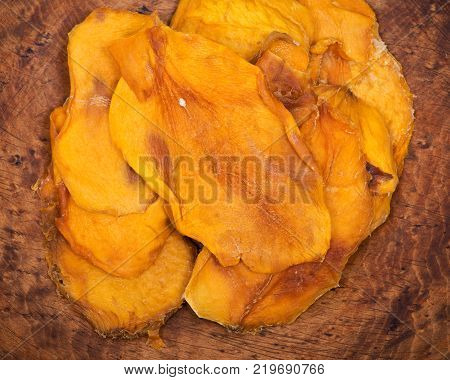 Unsweetened and unsulfured organic dried mango in wooden bowl