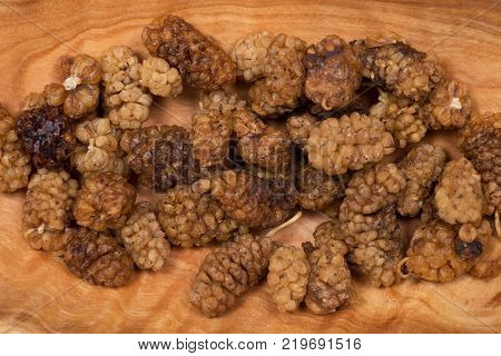 Organic unsulfured dried mulberries in wooden bowl