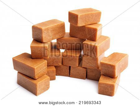 Delicious caramel candies on white background