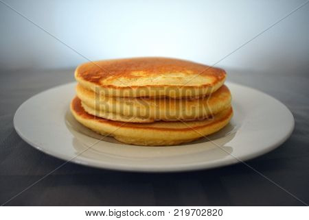 A stack of plain pancakes on a white plate
