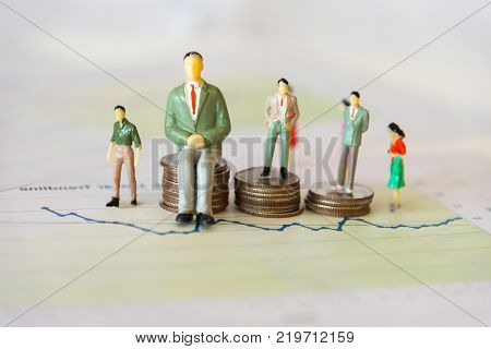 Miniature group businessman standing on money coin stack growing finance graph with project for presenting investment. Investment and Business Concept.