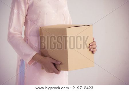 beautiful woman in pink dress and vietnam hat holding box