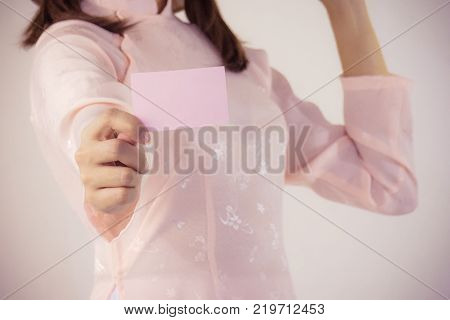 beautiful woman in pink dress and vietnam hat holding business card.