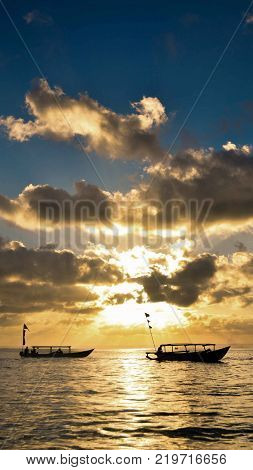 scenery of sunset in the middle of ocean and silhouette of fisherman boats