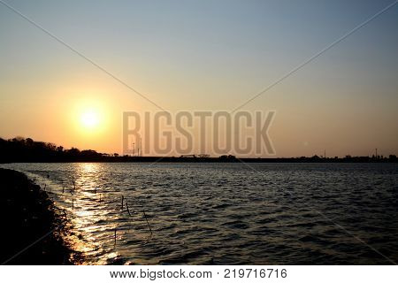 scenery of sunset and a lake and reflection of sun