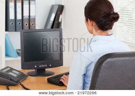 작업 하는 동안 키보드 입력에 아름 다운 여자의 뒤에서 보기