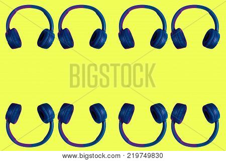 Multiple doubled wireless headphones on yellow background. Flat minimal style. Design and colors