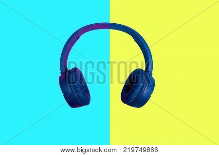 Top view on blue wireless headphones on vivid color background. Flat minimal style. Design and colors