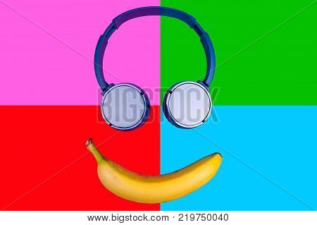 Pop art flat concept of banana and headphones on vivid colored background forming a smile face. Flat style and colors