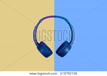 Top view on blue headphones on two colored background. Flat minimal style. Design and colors