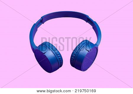 Top view on wireless headphones on vivid color background. Flat minimal style. Design and colors