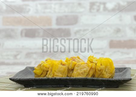 close up of shrimp wonton on black plate