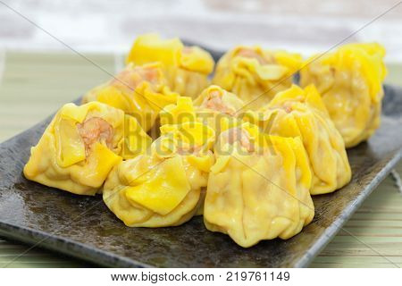 close up of shrimp wonton on black plate