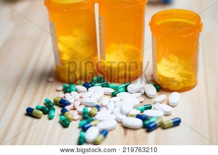 assortment of pharmacutical drugs with pill bottles in the background.