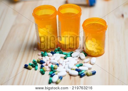 assortment of pharmacutical drugs with pill bottles in the background.