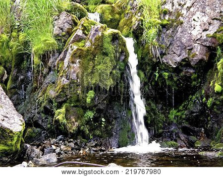 Waterfall From The Thawed Waters. Melting Snow In The Hilly Tundra. Waterfall