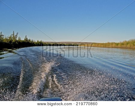 Waters of water from a motor boat in the river