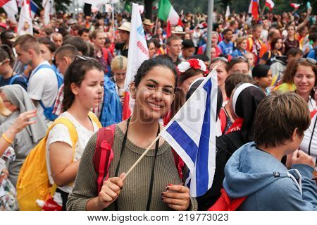 KRAKOW POLAND - 2016 - World Youth Day 2016 A crowd of people a young girl with a flag smiles