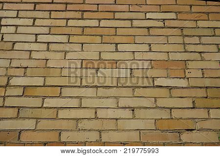The wall is made of yellow tiles of various colors can be used as a background.