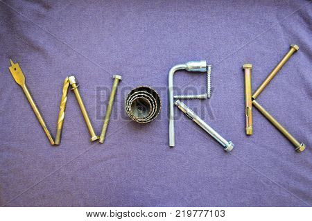 The inscription work is written by metal anchor bolts screws svermami wrenches. Work made up of objects. The word work is made up of a metalwork tool on a purple background.