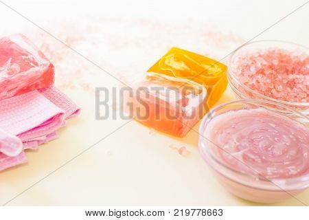 Luxirious spa facilities- glass clear bowls with bath salt and pink face or body cream and bars of homemade fruit soap. Space for a text or product display.