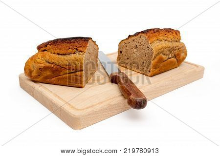 A homemade plumcake standing on a wooden board with a white background