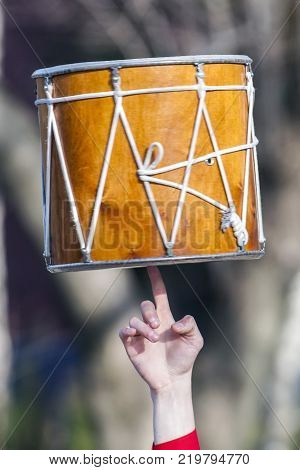 The musician rotates Dhol on one finger. Dhol can refer to any one of a number of similar types of double headed drum widely used, with regional variations, throughout the Indian subcontinent.