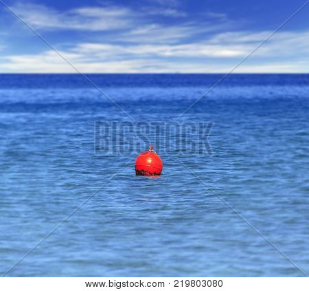Buoy At Blue Ocean Like Mergency Sign For Sailing Boat With Cloudy Sky Background